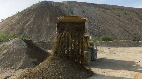 A front end loader machine tipping sand in a quarry. High quality photo