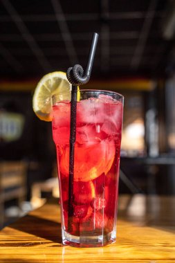 Büyük bardakta kırmızı bir karışım, buz, taze böğürtlen ve ahşap bir yüzeyde taze nane ve taze sıkılmış nar suyu serpiştirilmiş koyu siyah bir zemin üzerine serpilmiş. Yüksek kalite fotoğraf