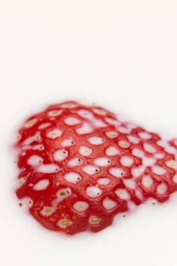 Çilek sütün içine düşüyor. Beyazda izole edilmiş. Yüksek kalite fotoğraf