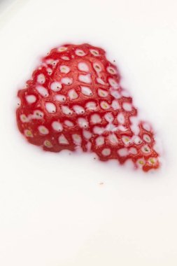 Çilek sütün içine düşüyor. Beyazda izole edilmiş. Yüksek kalite fotoğraf