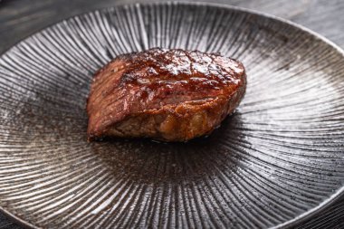 Karanlık bir arka planda taze sulu lezzetli biftek. Baharatlı ve otlu et yemeği. Yüksek kalite fotoğraf