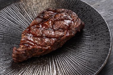 Karanlık bir arka planda taze sulu lezzetli biftek. Baharatlı ve otlu et yemeği. Yüksek kalite fotoğraf