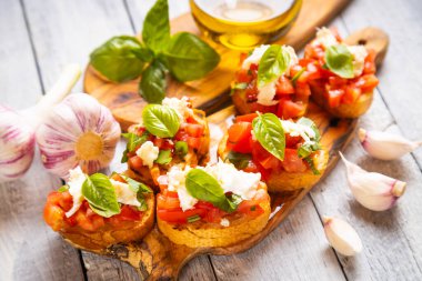 Klasik İtalyan bruschette ızgara ekmek dilimleri domates, fesleğen ve mozzarella peyniri.