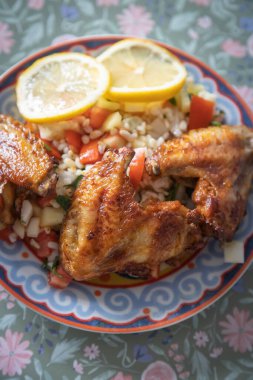 Kızarmış tavuk kanadı ve tabbouleh, salatalıklı bulgur salatası.