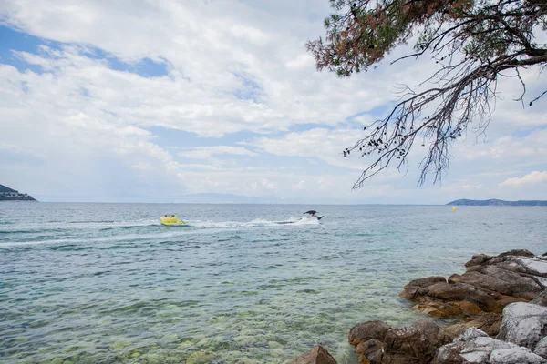 夏休みの観光客はスピードボートに乗るときに空気マットレスで楽しみを持っています ターコイズブルーの海の色 — ストック写真