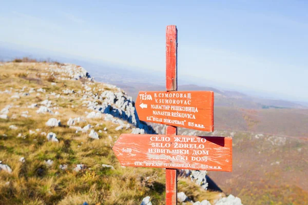 Hiking trail destination sign, the wooden marker at the ridge on Homolje mountains trails, eastern Serbia.