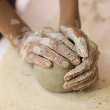 Kadın çömlek sanatçısı kil kalıbı için kil hazırlıyor. Kadın ellerine kille yakından bak. Yaratıcı el yapımı zanaat. 