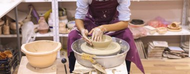 Çömlek atölyesi. Kadın seramik sanatçısı kil çömlek kalıbını çıkarıyor. Yaratıcı el yapımı zanaat. 
