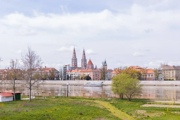匈牙利塞格德五彩斑斓的城市景观反映在下面的蒂萨河上 在一个晴朗的日子里 它被云彩和宏伟的建筑构成了框架 — 图库照片