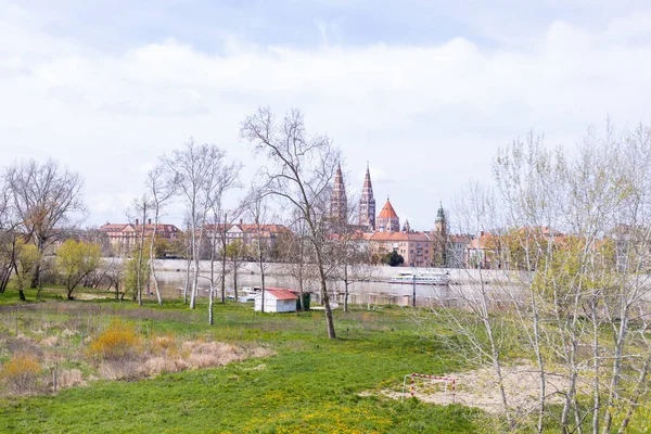 匈牙利塞格德五彩斑斓的城市景观反映在下面的蒂萨河上 在一个晴朗的日子里 它被云彩和宏伟的建筑构成了框架 — 图库照片
