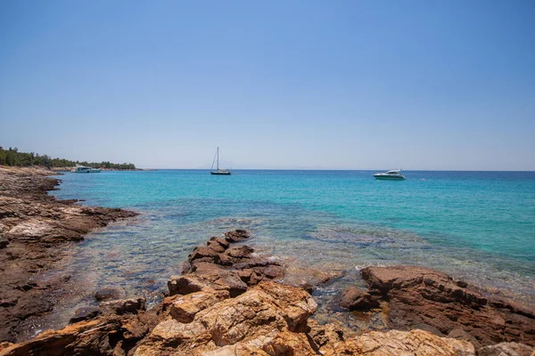 船在地平线上的晶莹晶莹的蓝色海水之上 自然美而不受影响的海岸是一个完美的旅游目的地 希腊海岸平静的夏日 — 图库照片