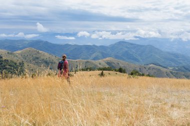Sırt çantalı kadın yaz manzarasının tadını çıkarıyor..