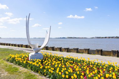 Sırbistan 'ın Palic Nature Park kentine yaptığı gezide doğanın güzelliğiyle dolu huzurlu ve manzaralı bir bahar günü. Huzurlu Palic Gölü 'ndeki anıtın etrafında renkli bulutlar ve açan çiçekler..