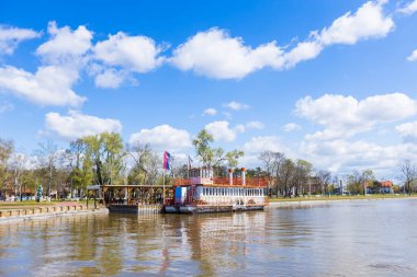 Sırbistan 'ın Palic Nature Park kentinde sakin bir yaz günü. Renkli bulutlar güzel mavi bir gökyüzünü süslüyor. Resmedilmeye değer bir göl ve bereketli bir manzara. Tatil için ilham verici bir yer..