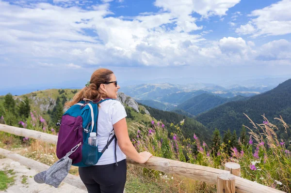 stock image Woman hiker enjoying summer nature landscape at mountains peak.