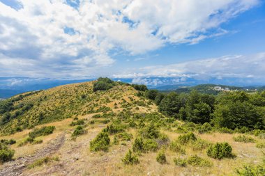 Dağlarda bulutlar ve mavi gökyüzü olan güzel dağ manzarası