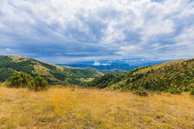 Dağlarda bulutlar ve mavi gökyüzü olan güzel dağ manzarası