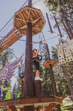 Genç kız ormanda heyecan verici bir halat macerasının tadını çıkarıyor..