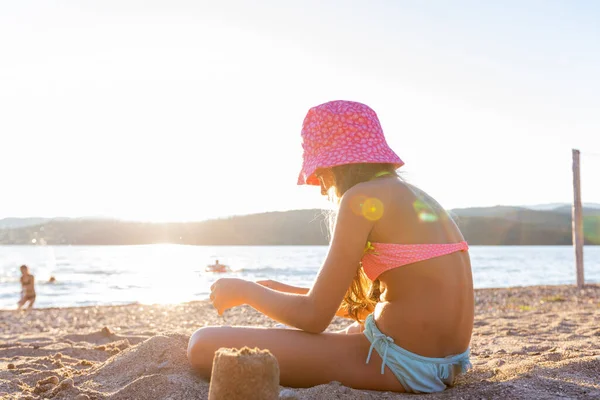 夏休みのサンドビーチでサンセットライトで遊ぶ子供 ロイヤリティフリーのストック写真