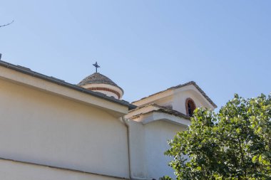 Yunanistan 'ın Thassos kentindeki büyüleyici Ortodoks kilisesi, beyaz cepheli, gri taştan çatılı, açık mavi gökyüzü altında. Kültürel ve mimari temalar için mükemmel, Başmelek Michael Manastırı.