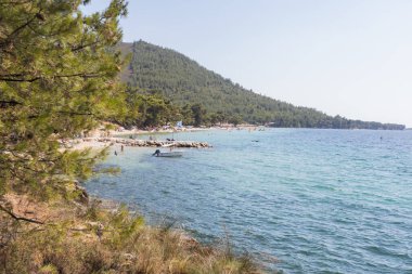 Çam ağaçlarıyla çevrili geniş bir sahil ve huzurlu bir sahil. Rahatlatıcı bir yaz tatili için ideal..