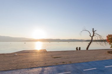 Doiran Gölü üzerinde sersemletici bir gün batımı sakin sular ve uzak dağlar boyunca sıcak yansımalar bırakıyor..