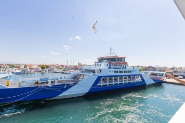 Ferry Arriving at Keramoti Harbor, Greece on a Sunny Day clipart