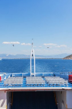 Bir feribottan güzel bir manzara, kristal berrak su ve martılarla Yunan kıyısı boyunca yelken açıyor..