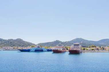 Yunanistan 'ın Thasos Adası' ndaki feribot limanı, feribotlar kenetlendi ve arka planda manzaralı dağ manzarası var.