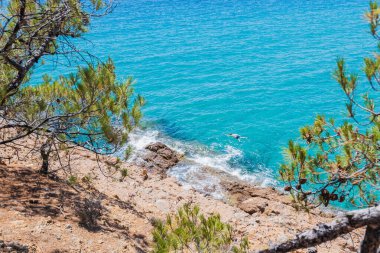 Yunan kıyı şeridinin çarpıcı manzarası, canlı turkuaz sular ve güneşli bir yaz tatili atmosferiyle.