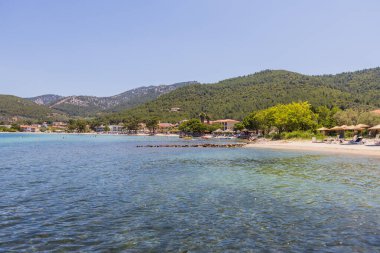 Idyllic Sahil Köyü yemyeşil tepeler ve berrak mavi sular arasında