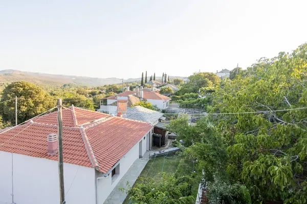 Thassos 'taki geleneksel bir Yunan köyünün çatılarının manzarası. Selvi ağaçları ve yemyeşil alanlar gün batımında yakalanır..