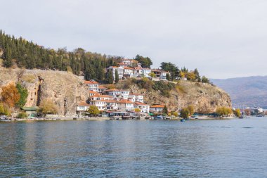 Ohri Gölü kıyısındaki kayalık, canlı sonbahar yapraklarıyla çevrili..