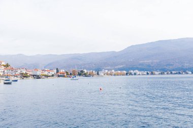 Ohri Gölü 'nde huzurlu bir sonbahar sabahı sakin sular, soluk renkler ve büyüleyici Ohri kasabası manzarası..