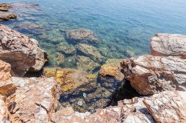 Yunanistan 'ın Thassos kentindeki kayalık bir kıyı şeridinde akan kristal berrak Akdeniz suları doğal güzellikleri sergiliyor.