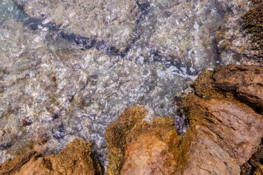 Okyanus Dalgaları, Kristal berrak sularla Rocky Shoreline 'ın üzerinde süzülüyor