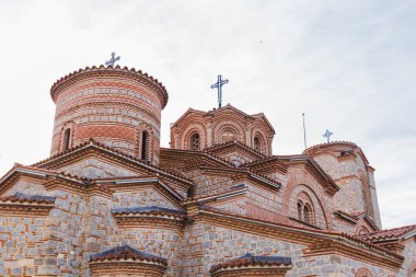 Makedonya 'nın Ohri kentinde yuvalanmış kırmızı kiremitli çatıları ve dini haçları olan şaşırtıcı Bizans tarzı taş ortodoks kilisesi.