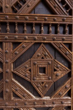 Çok güzel oyulmuş ahşap bir kapı, karmaşık geometrik desenler ve dekoratif elementler sergileniyor..