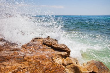Dinamik Okyanus Dalgaları Engebeli Kayaların Üzerinden Süzülüp Açık Gökyüzü Altında Taze Bir Sahil Pelerini Oluşturur