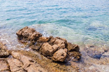 Okyanus Dalgaları, Kristal berrak sularla Rocky Shoreline 'ın üzerinde süzülüyor