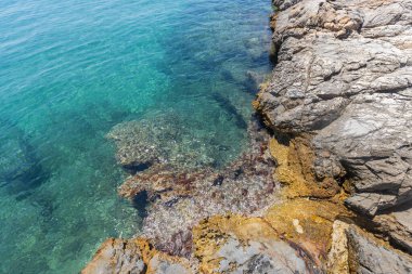 Güneşli bir Yaz Günü 'nde Yunanistan' da Kristal berrak sular ve Rocky Shoreline