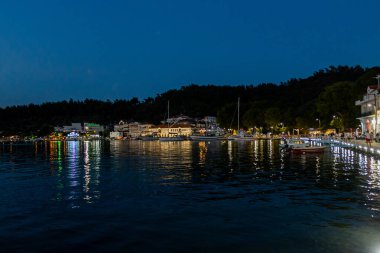Sıcak Sokak Işıkları ve Yunanistan 'ın Ev Işıklarıyla aydınlatılan Gece Sahil Kasabası