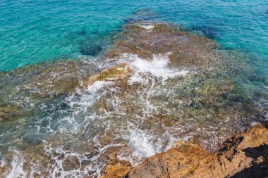 Yüzeyin altında rengarenk kayaları ve dokuları ortaya çıkaran berrak ve sığ sular..