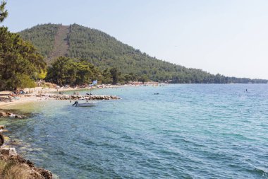 Çam ağaçlarıyla çevrili geniş bir sahil ve huzurlu bir sahil. Rahatlatıcı bir yaz tatili için ideal..