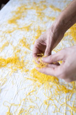 Taze Yapılmış Makarna İpliklerini Renkli Yüzeyde Tutan Eller