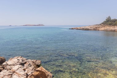 Kristal berrak turkuaz suları ve dramatik kaya oluşumlarıyla tenha bir kıyı koyunun nefes kesici manzarası..
