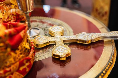 Karmaşık Tasarımlı Altın Ortodoks Haçı Süslü Dini Ögelerle çevrili Yansıtıcı Masa üzerine yerleştirildi