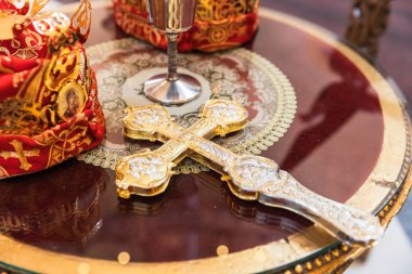 Karmaşık Tasarımlı Altın Ortodoks Haçı Süslü Dini Ögelerle çevrili Yansıtıcı Masa üzerine yerleştirildi