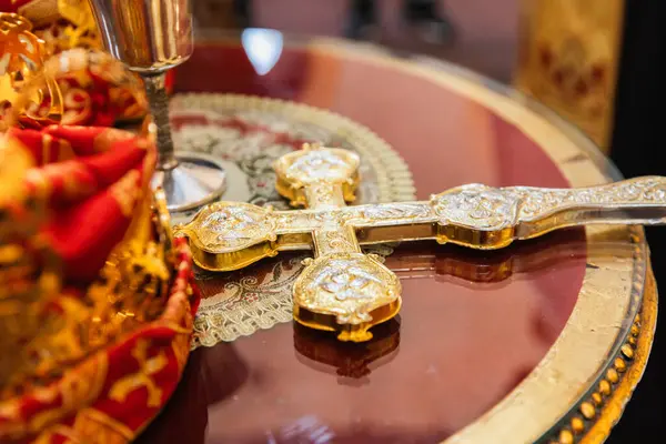 Karmaşık Tasarımlı Altın Ortodoks Haçı Süslü Dini Ögelerle çevrili Yansıtıcı Masa üzerine yerleştirildi