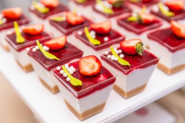 Zarif çilek bardakları krema, bisküvi ve ahududu soslu.